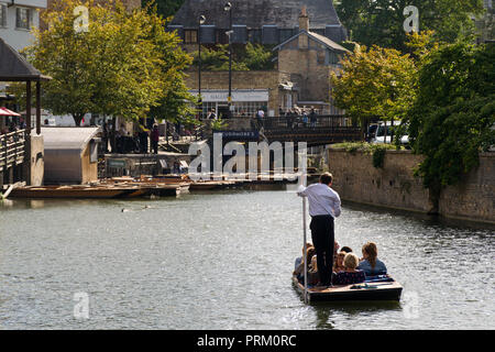 Un punt barca con più persone a bordo lungo il fiume Cam voce alla Maddalena Bridge in un assolato pomeriggio estivo, Cambridge, Regno Unito Foto Stock