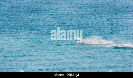 Jet Ski giostre e ingaggia a Newquay, Cornwall, getto sci visto in blu le acque del mare. Foto Stock