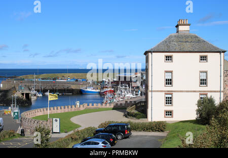 Vista al mare del Nord da Eyemouth, regione di frontiere, Scozia cercando passato Gunsgreen House e barche da pesca nel porto su una soleggiata giornata autunnale. Foto Stock