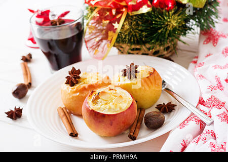 Farcite le mele al forno con formaggio, uvetta e mandorle per Natale su uno sfondo bianco. Xmas food dessert. Foto Stock