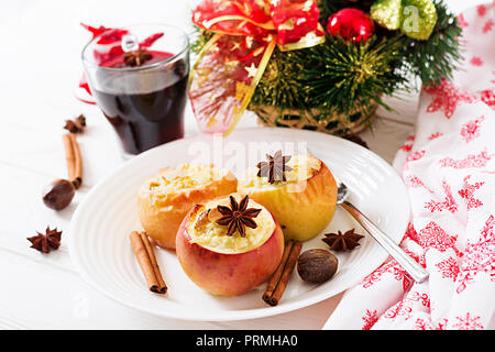 Farcite le mele al forno con formaggio, uvetta e mandorle per Natale su uno sfondo bianco. Xmas food dessert. Foto Stock