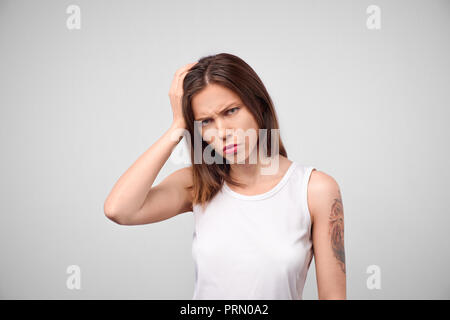 Il motivo è che. Bellissima femmina di metà lunghezza ritratto isolato su bianco studio backgroud. Giovane triste emotivo, frustrato e disorientati donna. Emo umana Foto Stock