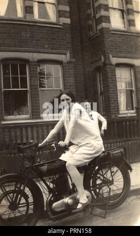 Giovane donna seduta su un 1922 Omega due moto di corsa in strada nel 1920s Foto Stock