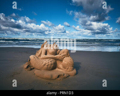 Chi poi creato un precedentemente la scultura di sabbia è quasi distrutto da un forte vento e il bue viene lasciato sulla spiaggia. Foto Stock