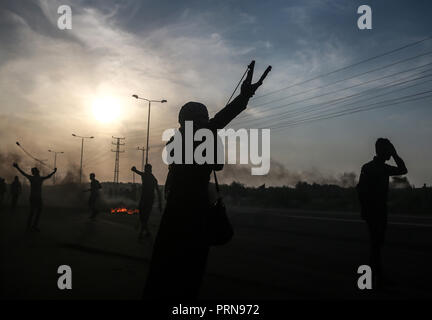 La striscia di Gaza. 3° Ott, 2018. Un manifestante palestinese utilizza una fionda di scagliare pietre contro soldati israeliani a Erez crossing vicino al confine con Israele, nel nord della Striscia di Gaza, ad Ottobre 3, 2018. Soldati israeliani appostati lungo il confine con il nord della Striscia di Gaza ucciso mercoledì sera un ragazzo palestinese durante gli scontri con decine di dimostranti palestinesi, i medici hanno detto. Credito: Xinhua/Alamy Live News Foto Stock