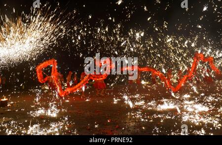 Puding, della Cina di Guizhou. 3° Ott, 2018. Artisti folcloristici stadio un folk mostrano in cui essi spray di ferro fuso per simulare la visualizzazione dei fuochi d'artificio, per turisti durante la giornata nazionale vacanze in Longchang township di Puding County, a sud-ovest della Cina di Guizhou, Ottobre 3, 2018. La mostra è stata iscritta nel patrimonio culturale immateriale elenco di Guizhou. Credito: Qin pista/Xinhua/Alamy Live News Foto Stock