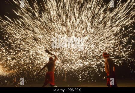 Puding, della Cina di Guizhou. 3° Ott, 2018. Artisti folcloristici stadio un folk mostrano in cui essi spray di ferro fuso per simulare la visualizzazione dei fuochi d'artificio, per turisti durante la giornata nazionale vacanze in Longchang township di Puding County, a sud-ovest della Cina di Guizhou, Ottobre 3, 2018. La mostra è stata iscritta nel patrimonio culturale immateriale elenco di Guizhou. Credito: Qin pista/Xinhua/Alamy Live News Foto Stock