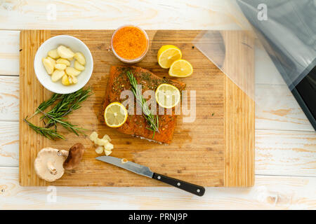 La preparazione di salmone per il sous vide la cena con rosmarino, aglio e limone gochujang infusa seasalt Foto Stock