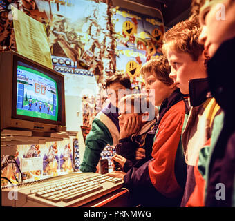 Swansea, Galles, UK Gennaio 1989. Un gruppo di bambini in un negozio di computer riuniti attorno un Atari ST giocando il gioco di Activision Enduro Racer. Foto Stock