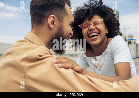 Felice giovane coppia multietnica di divertirsi e di ridere su strada Foto Stock