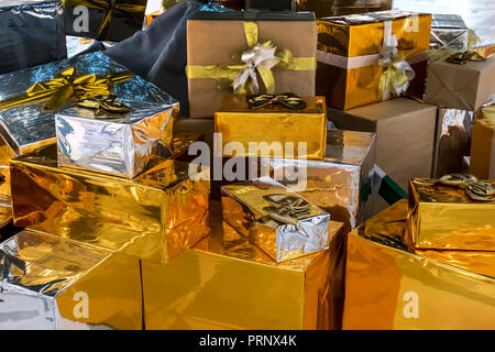 Un sacco di scatole regalo su sfondo bianco. Presenta in craft e carta colorata decorata con rosso di raso archi. Natale e gli altri giorni festivi concetto Foto Stock