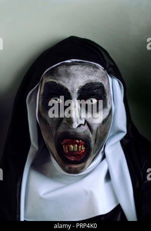 Primo piano di una spaventosa male nun, con denti di sanguinosi, indossando un tipico bianco e nero abitudine Foto Stock