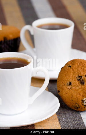 Due tazze di caffè e muffin closeup su sfondo tessili Foto Stock
