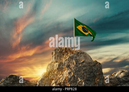 3D rendering di sventola bandiera brasiliana sul paesaggio roccioso per celebrare la festa nazionale del 7 settembre Foto Stock