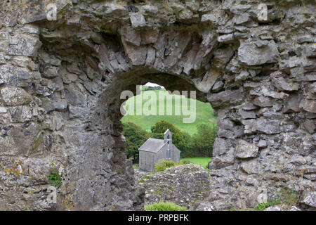 Veduta di una chiesa moderna attraverso la finestra aperta di un castello medievale rovina in Irlanda (Rock of Dunamase) Foto Stock