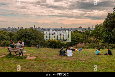 Le persone sono il divertimento e godetevi la skyline di Londra dalla sommità della collina del Parlamento, a Hampstead Heath, a nord-ovest di Londra. Foto Stock