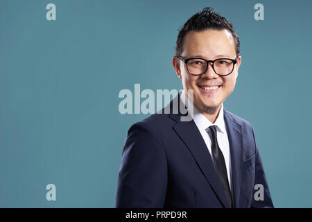 Ritratto di sorriso imprenditore asiatici in tuta . isolato su fondo azzurro . Foto Stock