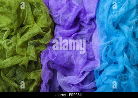 Tinti a mano a trama tessuto di garza di sfondo. Blu, viola e verde. Vista dall'alto. Foto Stock