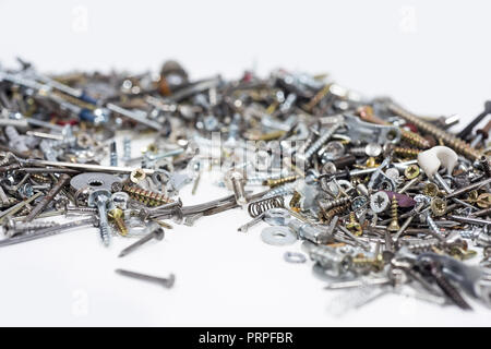 Un sacco di denti, viti, bulloni e umori su uno sfondo bianco. Foto astratte. Foto Stock