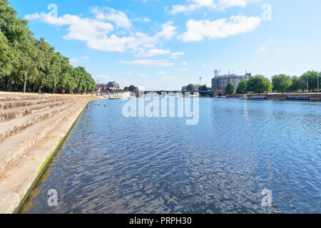 Guardando in giù il fiume Trent, verso Trento ponte nella distanza. Le imbarcazioni vengono ormeggiate sulla riva opposta Foto Stock