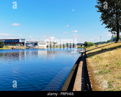 Guardando in giù il fiume Trent, verso Lady Bay bridge dove una chiatta fuoriesce da sotto il ponte. Sulla sponda sinistra sono magazzini e unità per uso industriale Foto Stock