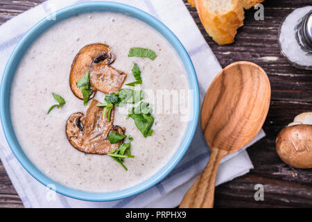 Deliziosi funghi champignon minestra di crema la purea su tavola in legno rustico. Vista dall'alto. Vista ravvicinata. Foto Stock