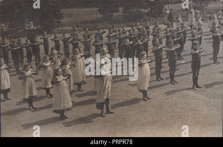 * Vintage fotografia della scuola i bambini nel parco giochi che prendono parte a esercitare il trapano Foto Stock