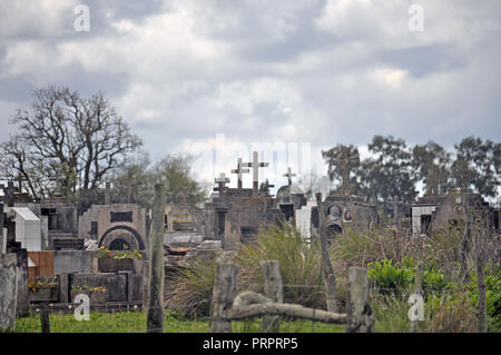 Gli oggetti contrassegnati per la rimozione definitiva nel cimitero contro il cielo nuvoloso Foto Stock