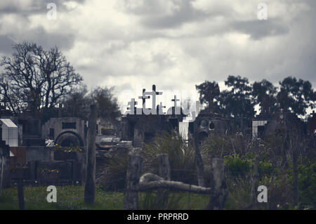 Gli oggetti contrassegnati per la rimozione definitiva nel cimitero contro il cielo nuvoloso Foto Stock