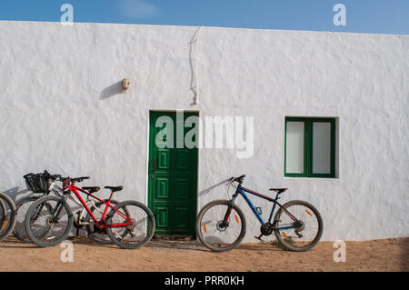 Lanzarote isole Canarie: biciclette sul muro di una casa bianca a Caleta de Sebo, il villaggio principale della Graciosa, l'isola dell'Arcipelago Chinijo Foto Stock