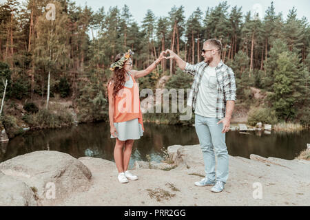 Giovani amare giovane avente incredibile data romantico vicino al bellissimo lago e rocce Foto Stock