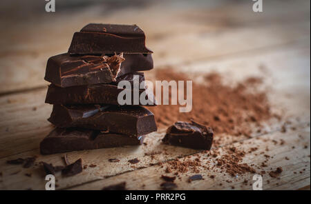 Close-up di una pila di cioccolato scuro su sfondo di legno Foto Stock