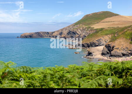 Pendinas Lochtyn visto attraverso la baia dal di sopra Llangrannog beach, Ceredigion, Galles Foto Stock