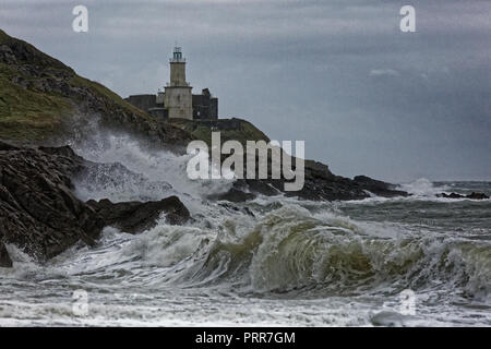 Onde infrangersi contro le rocce da Mumbles faro nel bracciale Bay, Swansea, Wales, Regno Unito Foto Stock