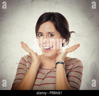 Soddisfatto giovane donna isolato su sfondo grigio Foto Stock