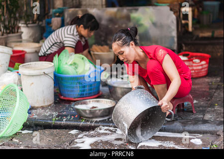 Hanoi, Vietnam - Ottobre 16, 2016. Donna lavando pentole e padelle con acqua e sapone per le strade di Hanoi, Vietnam. Foto Stock