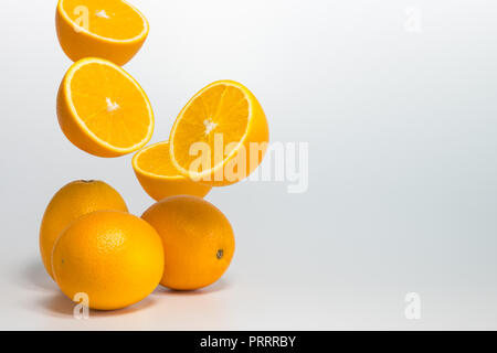 Cimelio di arancia navel levitare a metà in aria su sfondo bianco Foto Stock