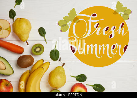 Vista superiore della frutta fresca e foglie di spinaci in bianco sullo sfondo di legno con spazio copia, fresca estate iscrizione Foto Stock