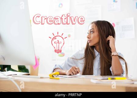 Malinconici African American imprenditrice che guarda lontano al lavoro in ufficio, iscrizione creativi e icona della lampadina Foto Stock