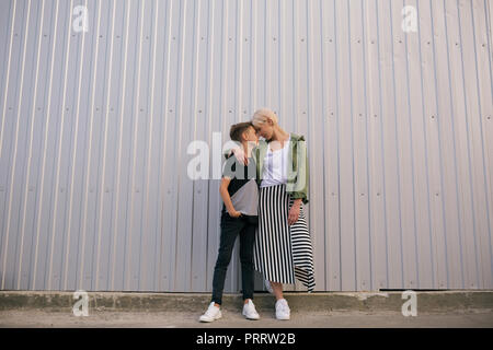 Lunghezza piena vista della madre e figlio di toccare fronte mentre in piedi e abbracciando su strada Foto Stock