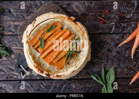 Vista in elevazione di una deliziosa torta di carote e le erbe sul tavolo di legno Foto Stock