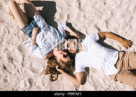 Vista superiore della coppia felice che giace sulla spiaggia di sabbia della città Foto Stock