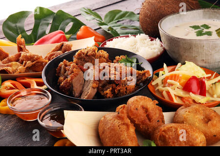 Cibo cinese con anatra fritto con salsa al curry. tom kah kai zuppa, gnocchi di patate e riso. Frittura di banane e verdure. Cibo di strada con wan tan Foto Stock