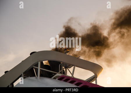 Fumo nero da una nave a partire i suoi motori principali e si prepara a lasciare Foto Stock