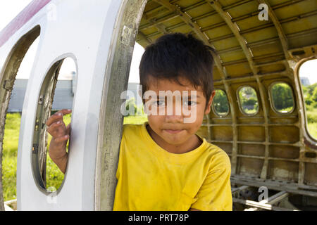 Giovane ragazzo giocando in piano di antichi relitti. Bangkok, Thailandia Foto Stock