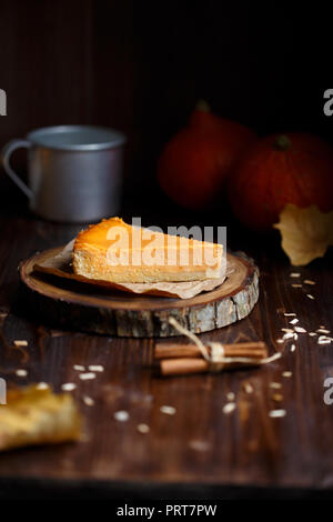 Cheesecake alla zucca, cucinato a casa, una tazza di caffè, zucca, prugna, vaniglia , sul fogliame di un legno tavolo scuro Foto Stock