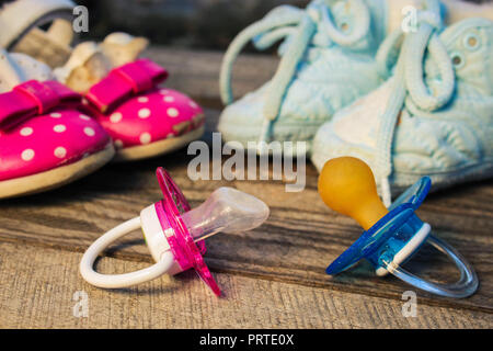 Scarpe per bambini e i succhietti rosa e blu Foto Stock