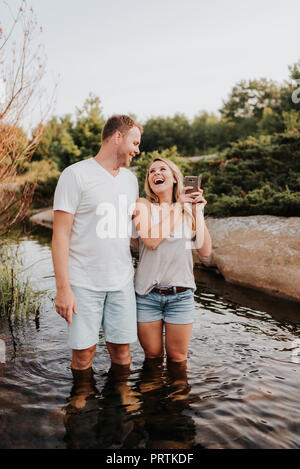 Giovane tenendo selfie in acqua, Algonquin Park, Canada Foto Stock