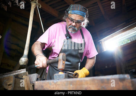 Fabbro lavora nella sua fucina Foto Stock