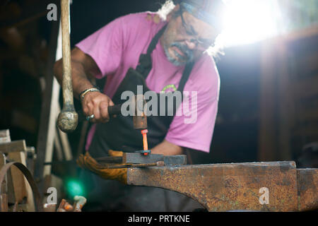 Fabbro lavora nella sua fucina Foto Stock